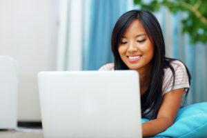 Portrait of young beautiful Asian woman with laptop